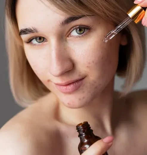 Close-up de mulher aplicando sérum facial no rosto