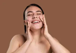 Mulher sorridente lavando o rosto com pele com acne Mulher sorridente lavando o rosto com pele com acne